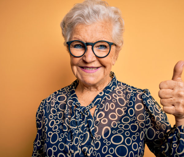 Elderly woman giving a thumbs up sign.